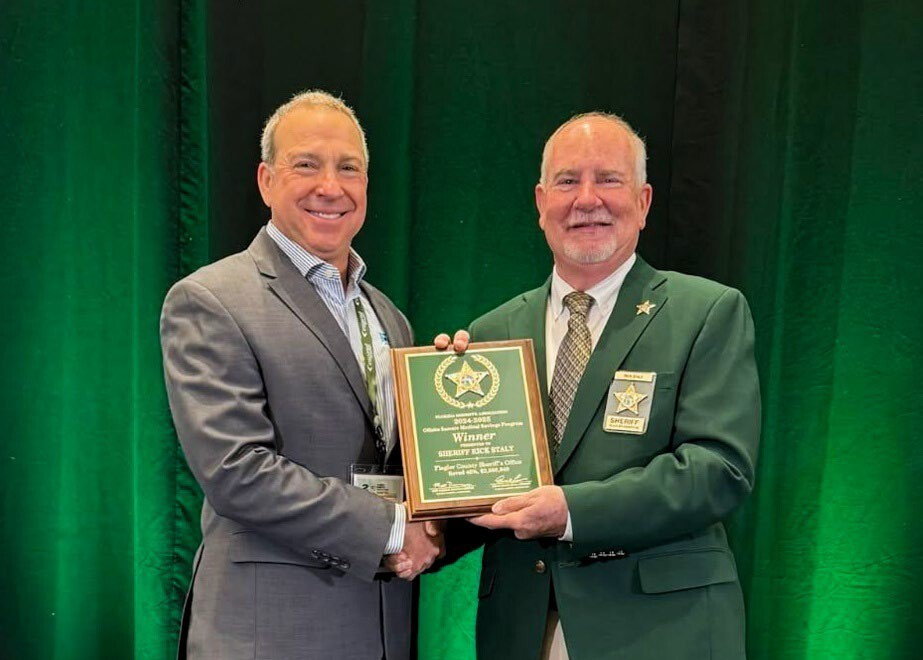 Flagler County Sheriff Rick Staly (right) receives the top saver award through the Florida Sheriffs Association’s Offsite Inmate Medical Savings Program from Nico Digioia, Director of Prime Health Services (left)