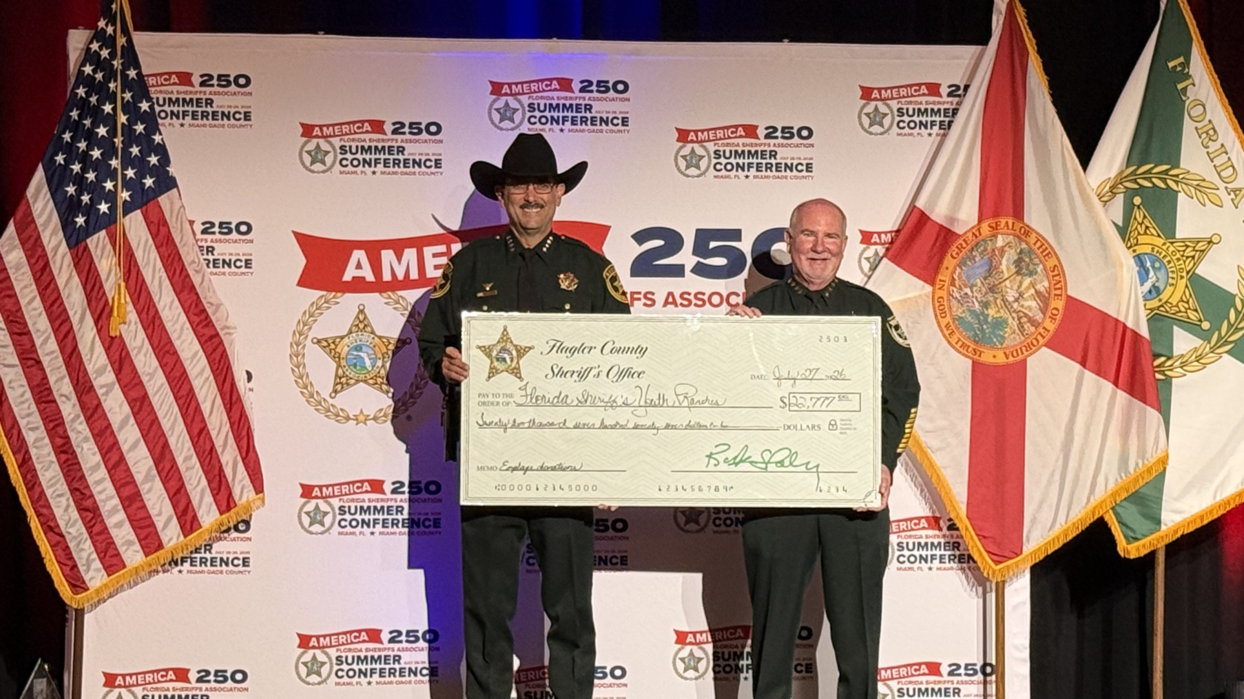 Flagler County Sheriff Rick Staly presents a donation check to Marion County Sheriff and FSYR Chairman Billy Woods.